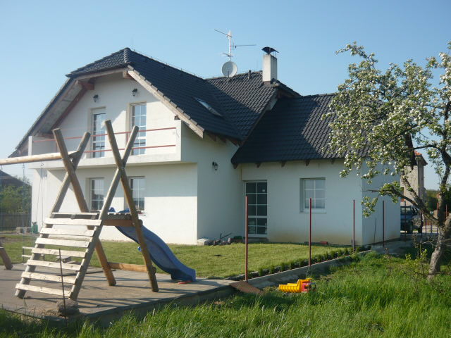 Bílý rodinný dům s tmavou střešní krytinou