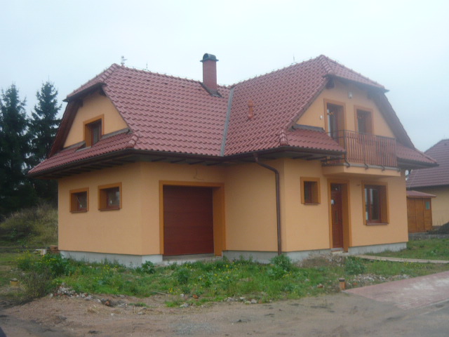 Rodinný dům s okrovou fasádou a červenou střechou
