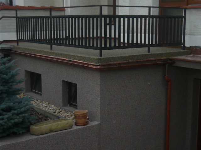 Balkon s kovovým zábradlím a dokončenou fasádou